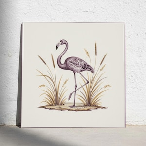 May include: A square wall art print featuring a detailed illustration of a single flamingo standing on one leg. The bird is rendered in shades of grey and purple, surrounded by tall, golden-brown stalks of grass on a solid off-white background.