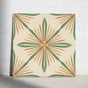 Può includere: Una piastrella decorativa quadrata con sfondo color crema e un motivo geometrico ripetitivo di linee radianti verdi e arancioni. Il design è composto da quattro quadranti che si allineano per formare un motivo centrale a stella.