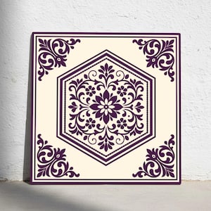 Peut inclure: Carreau décoratif carré avec un fond crème et un motif floral violet foncé. Le motif présente un hexagone central avec un motif floral et des coins décoratifs, créant un aspect symétrique et orné.