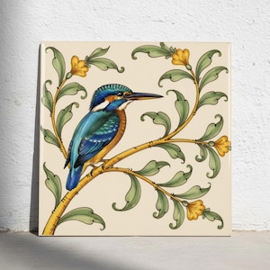 Könnte beinhalten: Eine quadratische Keramikfliese mit einem leuchtend blauen und orangefarbenen Eisvogel, der auf einem gelben Ast sitzt. Das Design zeigt stilisierte grüne Blätter und kleine gelbe Blüten auf einem cremefarbenen Hintergrund.