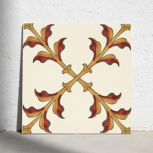 Puede incluir: Un azulejo de cerámica cuadrado con fondo color crema y un patrón botánico simétrico en forma de cruz. El diseño consta de cuatro motivos de hojas estilizadas en amarillo dorado y rojo oscuro que se encuentran en el centro del azulejo.