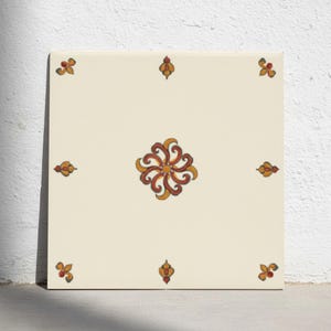 Op de afbeelding: Een vierkante keramische tegel met een gebroken witte basiskleur. Het midden is voorzien van een wervelend bloemmotief in tinten gebrand oranje en geel. Kleinere, symmetrische decoratieve accenten in hetzelfde kleurenpalet sieren elke hoek.