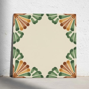 Può includere: Una piastrella quadrata in ceramica con un centro color crema e un bordo decorativo composto da motivi ripetuti a ventaglio nelle tonalità del verde bosco, verde oliva e marrone terracotta, disposti simmetricamente in tutti e quattro gli angoli.