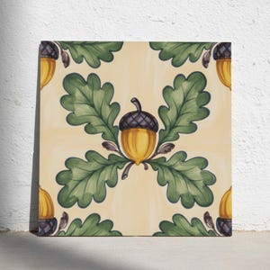 Può includere: Una piastrella decorativa quadrata con un motivo ripetuto di ghiande gialle con cappucci marrone scuro e foglie di quercia verdi su uno sfondo color crema chiaro. Il design centrale mostra una ghianda circondata da quattro foglie di quercia.