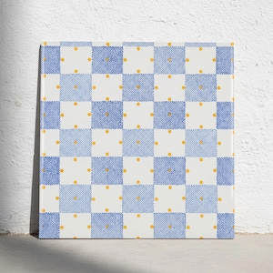 Puede incluir: Un azulejo de cerámica cuadrado con un patrón de tablero de ajedrez repetitivo de cuadrados blancos y azules con una textura punteada. Cada cuadrado blanco está acentuado con un pequeño punto amarillo centrado en el medio.