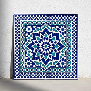 Puede incluir: Azulejo cuadrado con un patrón geométrico en tonos de azul, turquesa y blanco. El diseño presenta un motivo central en forma de estrella rodeado de intrincadas fronteras de formas repetidas. El azulejo está sobre un fondo blanco.