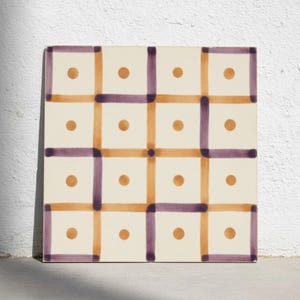 May include: A square ceramic tile featuring an off-white background with a grid pattern of intersecting purple and orange lines. Each of the sixteen squares within the grid contains a single centred orange dot, creating a repeating geometric design.