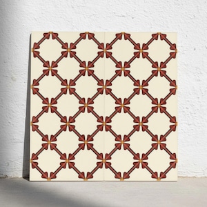 Op de afbeelding: Een vierkante decoratieve tegel met een herhalend geometrisch patroon van donkerrode pijlachtige vormen in een ruitvormig raster. Het ontwerp bevat kleine oranje cirkelvormige accenten op elk snijpunt tegen een effen crèmekleurige achtergrond.