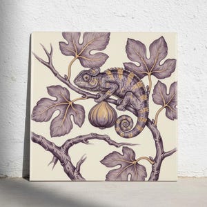 May include: A square wall art print featuring a detailed illustration of a chameleon perched on a branch of a fig tree. The chameleon is depicted in shades of purple and gold, surrounded by stylized fig leaves and a single hanging fig fruit.