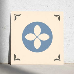 Puede incluir: Azulejo cuadrado con fondo crema. Un círculo azul en el centro contiene un diseño de flor de cuatro pétalos blanco. Los acentos de esquina gris oscuro completan el diseño.
