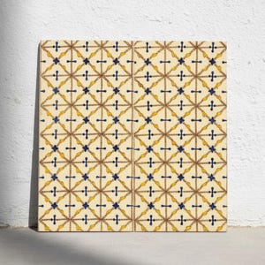 Könnte beinhalten: Eine quadratische Dekofliese mit einem sich wiederholenden geometrischen Muster aus sich kreuzenden braunen seilartigen Linien auf cremefarbenem Grund. Das Design enthält kleine dunkelblaue kreuzförmige Akzente und gelbe blattartige Motive.