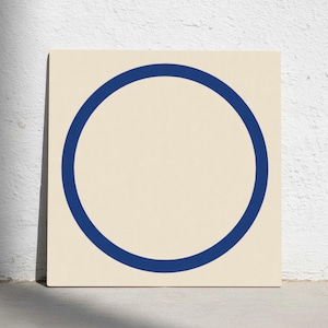Peut inclure: Toile carrée avec un cercle bleu marine sur fond crème. Le design minimaliste est simple et moderne, adapté à divers styles d'intérieur. L'œuvre est accrochée à un mur blanc.