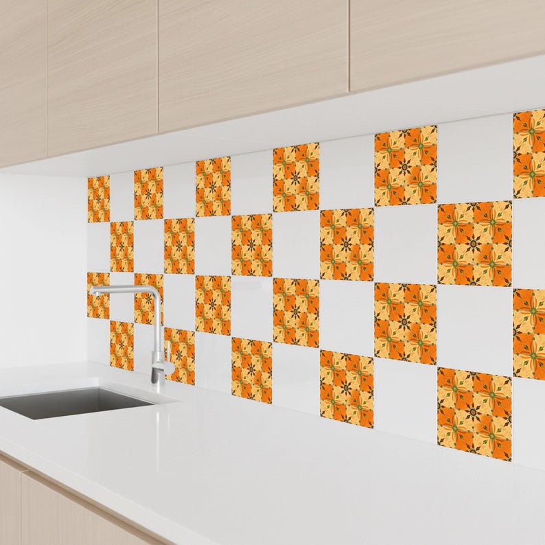 May include: A kitchen backsplash featuring a repeating pattern of orange, yellow, and green floral designs on white square tiles. The tiles are arranged in a checkerboard pattern above a white countertop and sink.