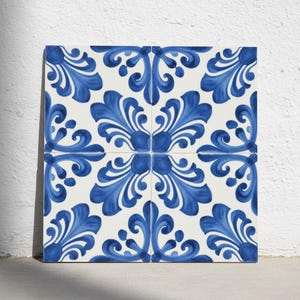 Puede incluir: Un azulejo de cerámica cuadrado con un patrón repetitivo de volutas de inspiración floral en azul sobre un fondo blanco. El diseño consta de cuatro cuadrantes simétricos que se alinean para formar un motivo botánico continuo y complejo en azul intenso.