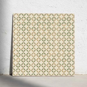 May include: A square tile featuring a repeating geometric pattern of four-pointed stars in muted olive green and soft tan colours against a cream background. The design consists of interlocking star shapes that create a consistent grid layout.