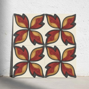 Könnte beinhalten: Eine quadratische dekorative Fliese mit einem sich wiederholenden Muster aus vier stilisierten Blumenmotiven. Jedes Motiv besteht aus vier spitzen Blütenblättern in Dunkelrot und Goldgelb, die dunkelgrau auf cremefarbenem Grund umrandet sind.