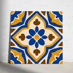 May include: Square tile with a symmetrical floral design. The pattern features a central blue flower with yellow and brown accents, set against a cream background. The border is a combination of blue and yellow.