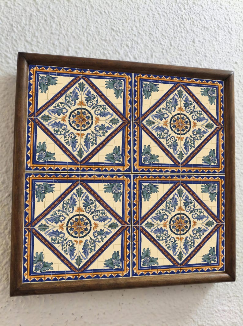 May include: A framed set of four decorative ceramic tiles. Each tile features a cream-colored background with a blue, yellow, and green floral design. The tiles are framed in a dark brown wooden frame, creating a cohesive decorative piece.