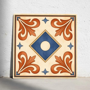 Puede incluir: Azulejo decorativo cuadrado con fondo crema, con un rombo azul central con un círculo blanco. El azulejo tiene diseños anaranjados en forma de hoja en cada esquina y acentos de estrella azul. Un borde oscuro enmarca el diseño.