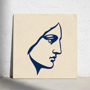 Puede incluir: Impresión artística cuadrada con un dibujo lineal minimalista de un perfil en azul marino sobre un fondo crema. La obra de arte representa un rostro estilizado con nariz, ojo y labios definidos.