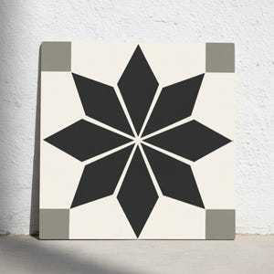Puede incluir: Azulejo cuadrado con fondo crema y diseño de estrella negra. La estrella está compuesta por formas de diamante. Cuadrados grises en cada esquina del azulejo.