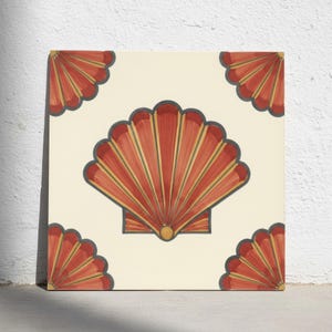 Puede incluir: Un azulejo cuadrado de cerámica con fondo color crema y un gran motivo central de una concha de vieira de color naranja rojizo. Cuatro diseños parciales de conchas a juego están situados en cada una de las cuatro esquinas del azulejo.