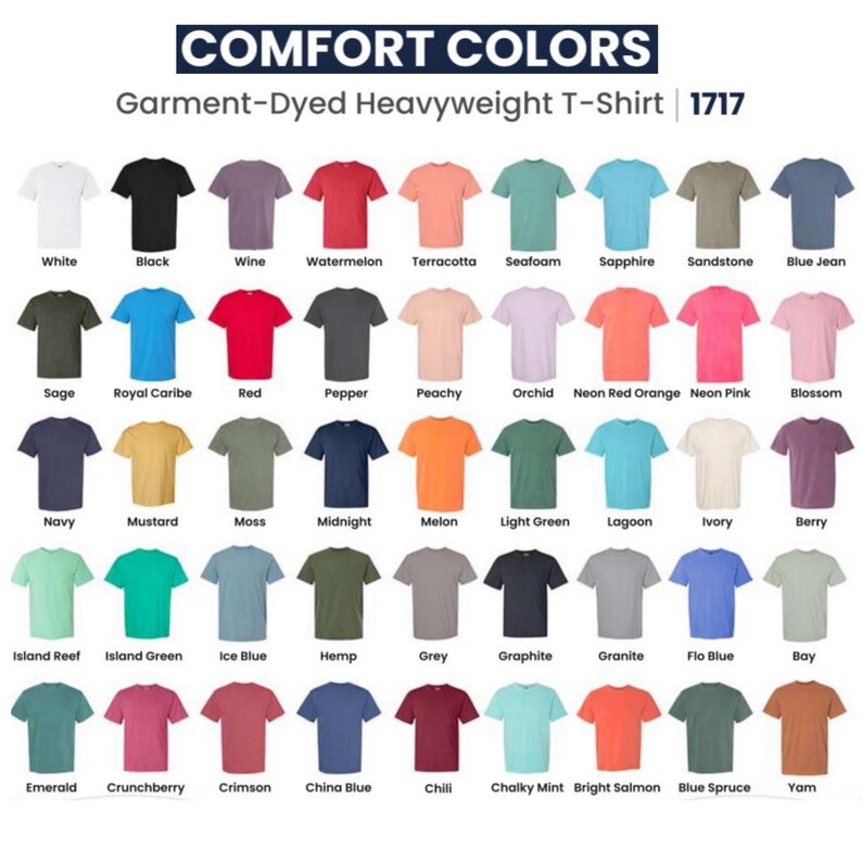Op de afbeelding: Een display van Comfort Colors garment-dyed heavyweight t-shirts in diverse kleuren. De afbeelding toont een breed scala aan tinten, van wit tot zwart, rood en blauw, waarbij elk shirt is gelabeld met zijn kleurnaam.
