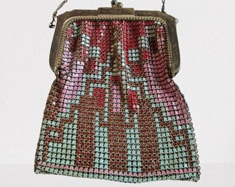 May include: Vintage metal mesh purse with a decorative geometric pattern in shades of red, pink, brown, and teal. The purse has a metal frame and a chain handle. A classic accessory.
