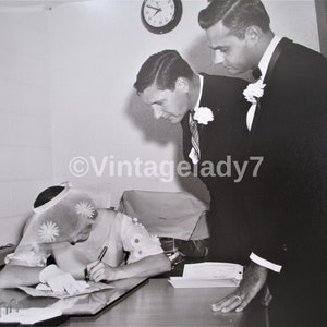Zdjęcie archiwalne z 1966 r., druhna honorowa podpisuje licencję małżeńską, sukienka Daisy z kapeluszem Daisy, archiwum FOTOGRAFA, jedyny w swoim rodzaju, 8X10
