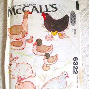 May include: A white McCall's 6322 sewing pattern envelope featuring illustrations of a goose, a hen with chicks, ducks, two rabbits, and a bird. The envelope includes the text McCall's 6322, $2.00, and pattern/patron printed on the front surface.