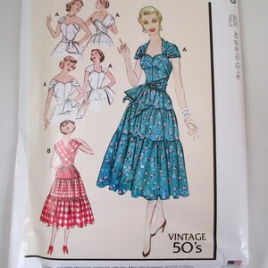 Puede incluir: Un paquete de patrones de costura vintage de McCall's con ilustraciones de vestidos de los años 50. El paquete incluye diseños de vestidos con estampados florales azules y cuadros rojos, con el texto "VINTAGE 50'S" e información de tallas.