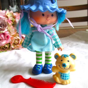Lalka Vintage Blueberry Muffin Strawberry Shortcake z kapeluszem, sernikiem i grzebieniem z czerwonymi jagodami 1979 Lalka Blueberry Muffin