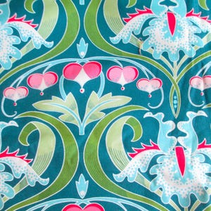 Peut inclure: Un tissu présentant un motif répétitif de grandes fleurs stylisées bleu clair et blanches avec des centres rose vif, entremêlées de petites fleurs roses en forme de cœur et de feuilles vertes incurvées sur un fond bleu sarcelle.