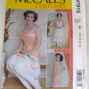 Op de afbeelding: McCall's Costumes naaipatroon M7915. Het patroon toont een vrouw in een perzik- en witte jurk met een lijfje in korsetstijl. Het patroon bevat meerdere aanzichten en maten A5 (6-8-10-12-14). De ontwerper is Angela Clayton.