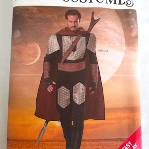 May include: Simplicity Costumes sewing pattern for a fantasy and cosplay outfit. The pattern features a man in a costume with a brown cape, black pants, and a silver and black top. The pattern includes sizes XS-XL.