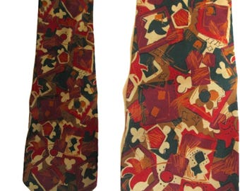 Op de afbeelding: Een stropdas met een patroon met een herhalend ontwerp van abstracte vormen in bordeauxrood, rood, groen en beige. De stropdas heeft een klassiek puntig uiteinde en is gemaakt van een gladde stof.