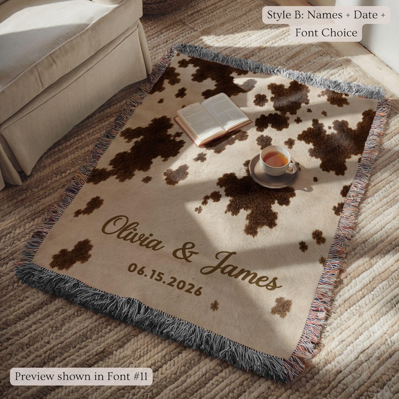 Personalized cow print woven blanket with custom couple names and wedding date, brown and cream western pattern, rustic farmhouse wall decor, fringe edges, and cozy country wedding keepsake style.