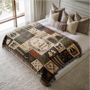 May include: A woven throw blanket featuring a patchwork design with Halloween-themed illustrations including ghosts, pumpkins, black cats, bats, and floral wreaths. The center displays the text Sarah & James EST. 2026 within a decorative frame.