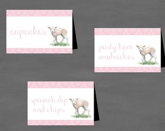 Op de afbeelding: Drie roze en witte voedseltentkaarten met een lammetjesillustratie en tekst die "cupcakes", "feestjes ham sandwiches" en "spinaziedip en chips" luidt.