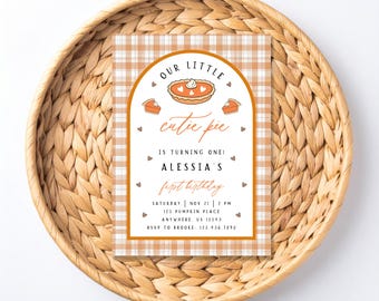 May include: A rectangular birthday invitation card with a white and orange plaid background. The center features an orange arched frame containing illustrations of pumpkin pies and the text: OUR LITTLE cutie pie IS TURNING ONE! ALESSIA'S first birthday, with event details including date, time, location, and RSVP information.