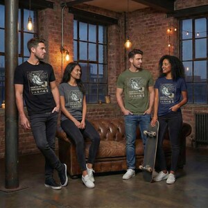 May include: Four people wearing graphic t-shirts with a vintage-style illustration and Japanese text. The shirts are black, gray, olive green, and navy blue. The setting is a room with exposed brick walls, large windows, and a leather couch.