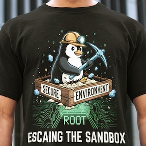 May include: Black t-shirt with a cartoon penguin wearing a hard hat and holding a pickaxe. The penguin is in a wooden box labelled "Secure Environment". Below, the text reads "Root Escaping the Sandbox".