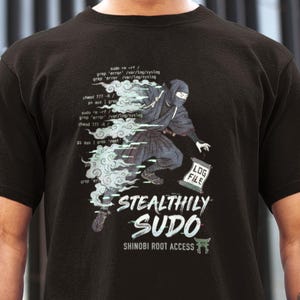 Może przedstawiać: Czarna koszulka z grafiką ninja i napisem "STEALTHILY SUDO SHINOBI ROOT ACCESS". Projekt zawiera ninja, "LOG FILE" i fragmenty kodu.