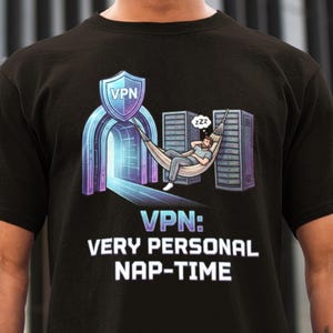 Puede incluir: Camiseta negra con un diseño gráfico. El diseño presenta un escudo con "VPN", un arco, una persona durmiendo en una hamaca y servidores. El texto dice "VPN: VERY PERSONAL NAP-TIME."