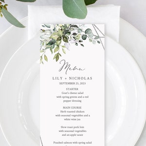 Puede incluir: Una tarjeta de men&uacute; de boda con un dise&ntilde;o floral verde y blanco. El men&uacute; incluye opciones de entrante, plato principal y postre. El texto en la tarjeta dice "Lily + Nicholas, 25 de septiembre de 2023".