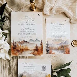 May include: A wedding invitation suite with a watercolor illustration of a mountain landscape with a lake and trees in autumn colors. The invitation includes the names Riley Hodgson and Shaun Parkinson, the date October 15th, and the location North Lakes Country Club. The RSVP card includes a QR code for guests to respond online.