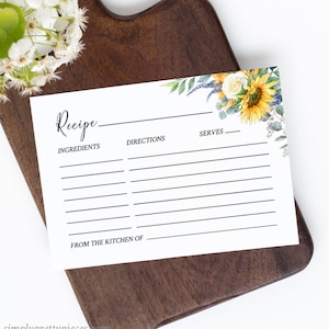 May include: A blank recipe card with a watercolor floral design featuring sunflowers, white roses, and eucalyptus leaves. The card has sections for ingredients, directions, serves, and from the kitchen of.