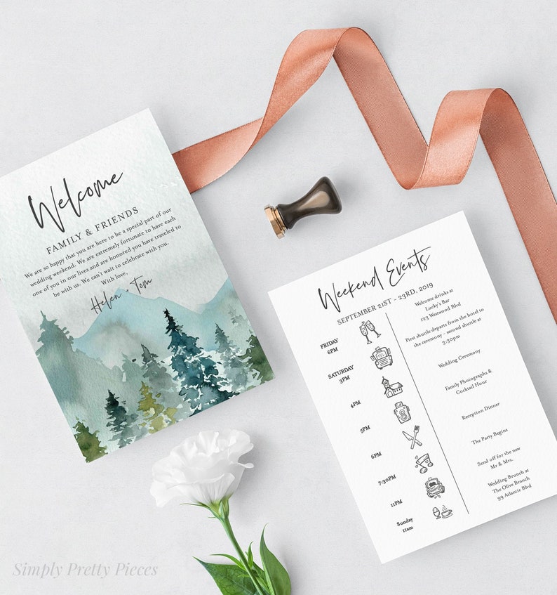 May include: A wedding invitation suite with a watercolor mountain landscape design. The invitation includes a welcome message for family and friends, and a weekend events schedule with details for the wedding ceremony, reception, and other activities.