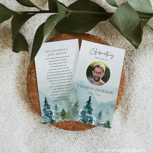 May include: Two memorial cards with a watercolor background of a forest scene. The top card has a poem about a person's journey continuing after death. The bottom card has a photo of a man and the text "Celebrating the Life of Thomas Jackson 19XX-20XX".