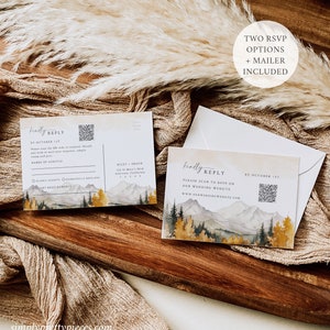 May include: Two RSVP cards with a mountain and forest watercolor design. The cards have a QR code and text that says "kindly reply" and "please scan to RSVP on our wedding website".